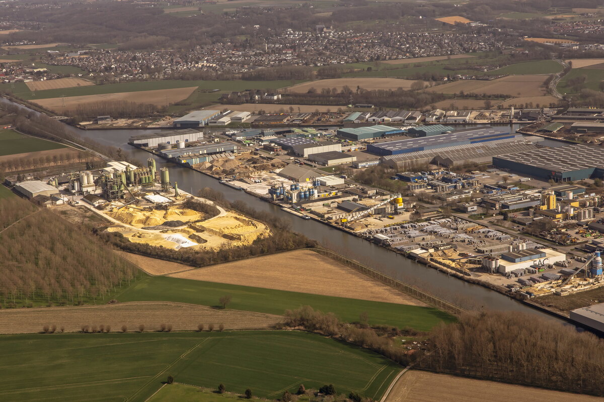 Aerial photo of Beatrixhaven Maastricht – factories with solar panels on the roofs. Various factories are visible across the landscape. In the background, you can also see residential homes and the canal along which the factories are located.