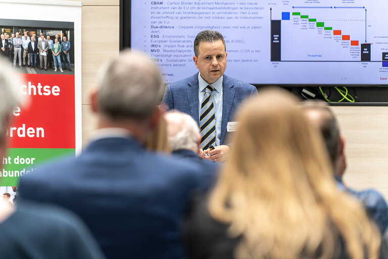 Spreker Robert van der Ven Laura Metaal tijdens MEA Kennissessie 18 april 2024. Robert staat voor de groep en achter hem zie je een presentatiescherm. Je kijkt tegen de rug op van een viertal aanwezigen waarvan drie mannen en een vrouw.